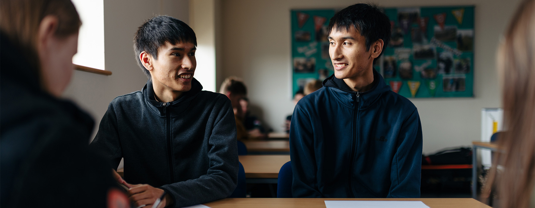 Business students looking and smiling at each other