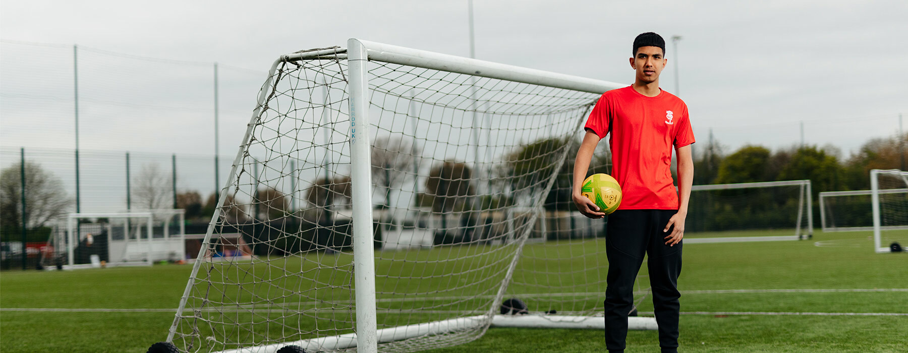Lincoln City Shadow Academy student outside goal holding football