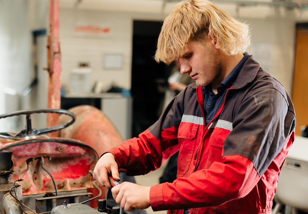Engin callout Riseholme College Engineering student fixing red tractor