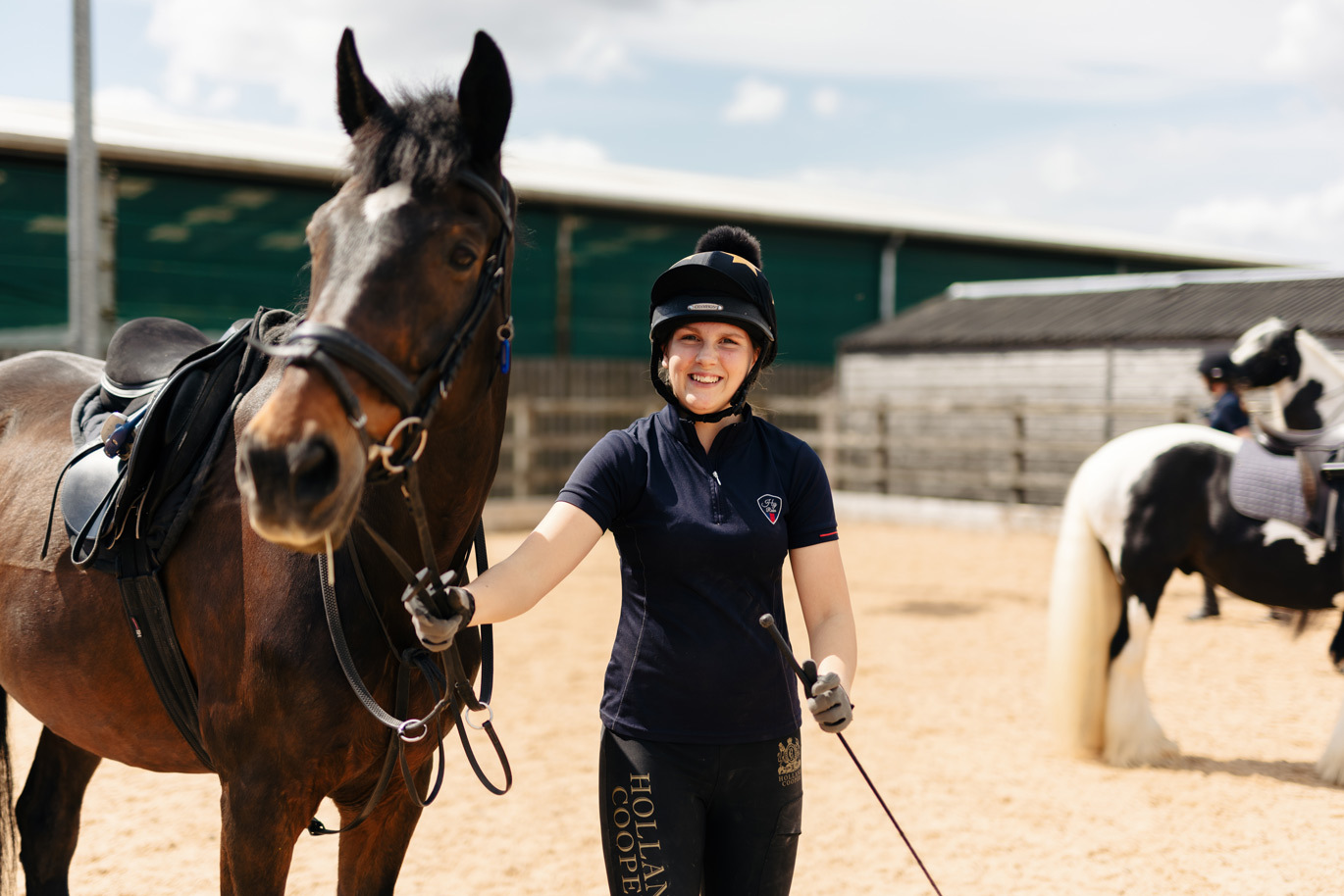 Equine student smiling with horse at ourdoor arena