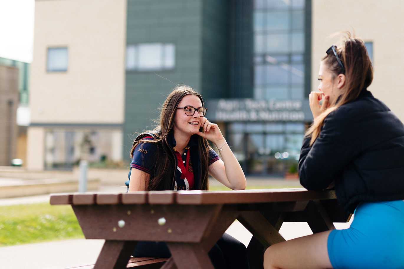Riseholme College students sitting on bench laughing