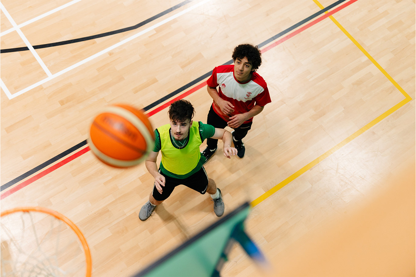 Sport students playing basketball in sports hall