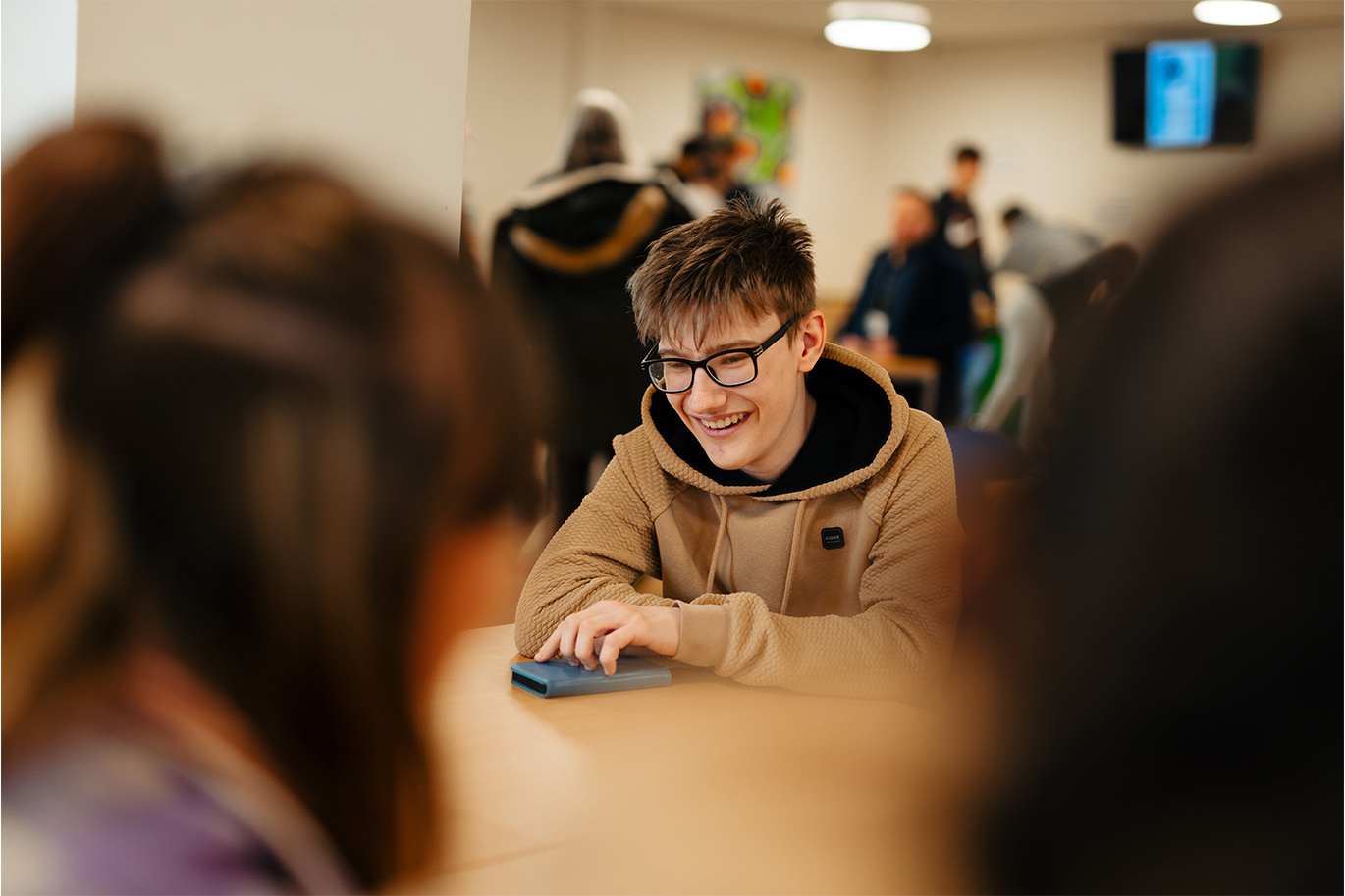 Student smiling sat in college refectory