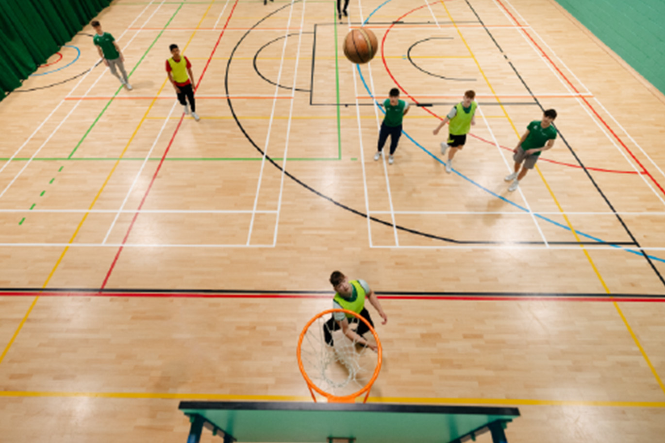 Students on Sport course playing basketball in Sports Hall